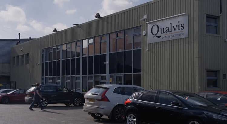 Front exterior view of the Qualvis building. Cars are parked in the foreground