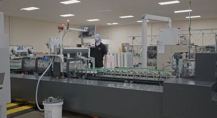 A man makes selections on the touchscreen interface of the folder-gluer