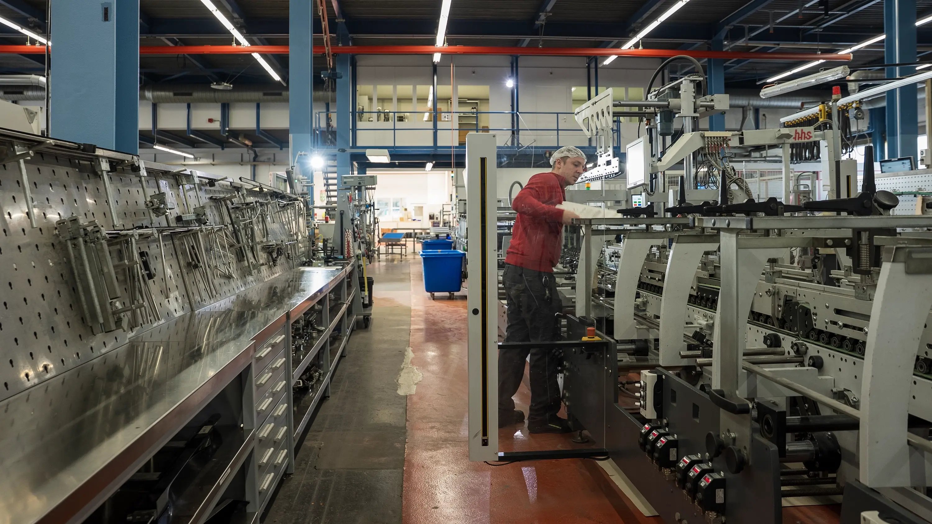 Un uomo ispeziona una piega-incollatrice.